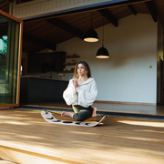 Women practicing yoga using a moon slackboard in a modern living room